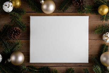 Christmas canvas mockup with fir branche, golden balls festive decoration, Christmas tree on wooden...