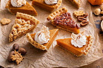 Variety of Thanksgiving pie slices on parchment paper - obrazy, fototapety, plakaty