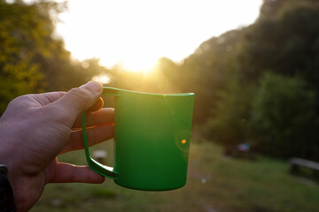 Tourist cup of coffee in the morning forest.