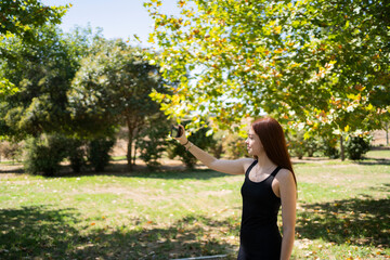 Young woman taking selfie in the park while exercising
