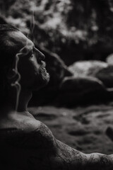 A man in a sacred temple with a waterfall in Bali, incense, Bali traditions, places of power.