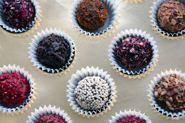 Top view of different small chocolate candies in a box.