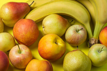 Various fruits on a yellow background. Fruit as a background for your image