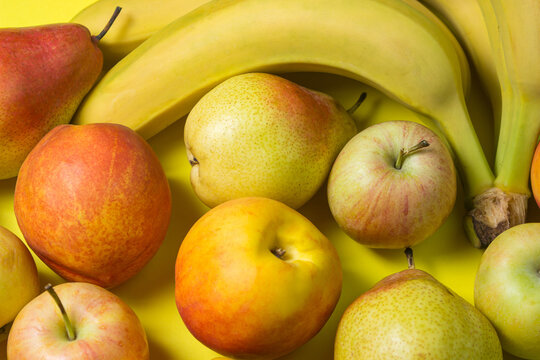 Various fruits on a yellow background. Fruit as a background for your image