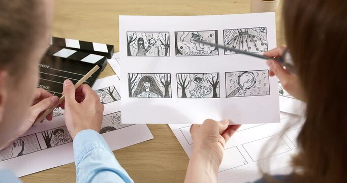 The storyboard for the film is in the hands of the director. Drawn characters on paper.
