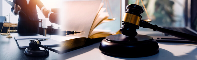 Judge gavel with Justice lawyers having team meeting at law firm in background. Concepts of law.