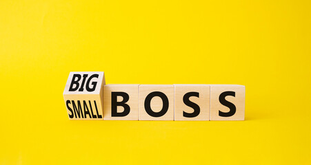 Big vs small boss symbol. Turned wooden cubes with words Small boss and Big boss. Beautiful yellow background. Business concept. Copy space.
