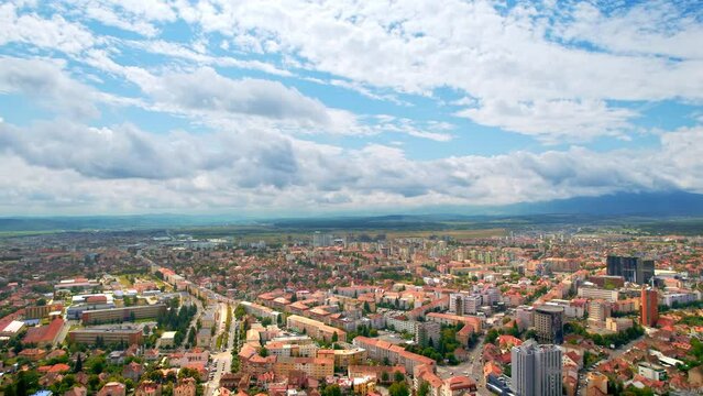 Aerial drone view of Cluj, Romania. Cityscape, roads with cars, old buildings, greenery