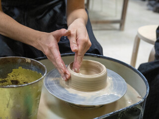 A close-up of a craftsman making an object out of clay on a potter's wheel. Handmade, hobby, hobby,...