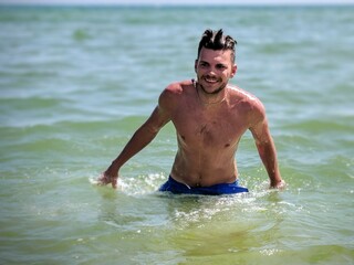 man grinning and super happy in the sea in portugal