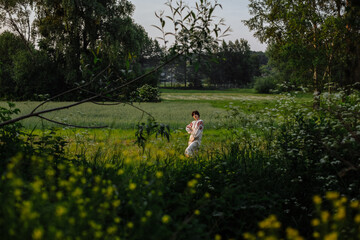 a girl in a national dress on a background of green plants
