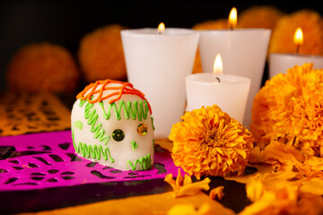 Sugar skulls with Candle, Cempasuchil flowers or Marigold and Papel Picado. Decoration traditionally used in altars for the celebration of the day of the dead in Mexico