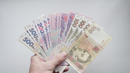 Ukrainian money denominated one hundred, two hundred, five hundred hryvnia in the hands of a man