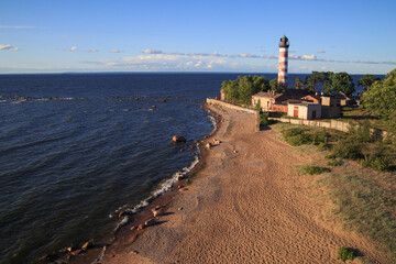 Fototapeta na wymiar Landscape with a lighthouse on the seashore in a summer evening.