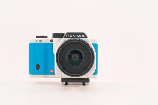 macchina fotografica digitale Pentax K-01 con corpo azzurro bianco su sfondo bianco