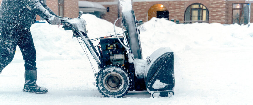 Manual Turbine Snowplow With Motor Driven By An Operator Dressed In Red During A Day With A Heavy Snowfall.