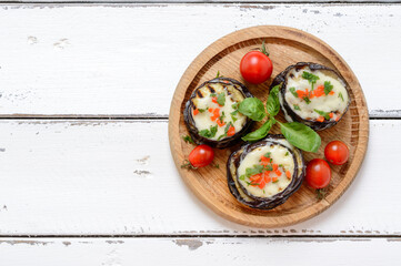 Baked eggplant, tomatoes and cheese on table. Top view with copy space