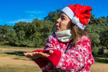 Obraz premium Adorable little girl enjoying Christmas, wearing Christmas clothes and earmuffs. Image with copy space