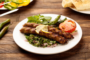 Chicken Kebab with salad served in a dish isolated on wooden table background side view of fastfood