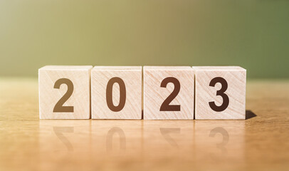 2023 year numbers on wood dices on green background.