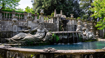 Two sculpted statues with a waterfall fountain in the middle. Villa Lante, Bagnaia, Italy