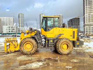 construction equipment on site. building houses and laying roads. bright, yellow excavator for digging holes and laying plumbing communications