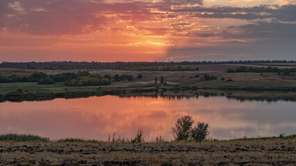 Fototapeta na wymiar Looking towards the setting sun from a high river bank.