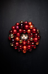 curious cat with red christmas bauble wreath portrait on black background with copy space