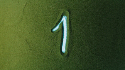 Hand drawing Number One 1 Symbol in the Green Sand. Male hand writes a number on the green sand...