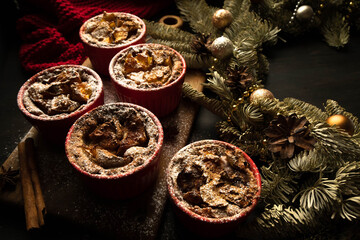 Christmas composition. Christmas cupcakes in red plates. Traditional holiday dessert. Copy space. Dark background.