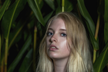 Fototapeta premium Blonde young woman poses outdoors closeup. Horizontally. 
