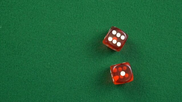 Two red roll dices and stops on the table with 6 and 1 in slow motion.