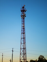 Cellular repeater tower against a blue sunset sky