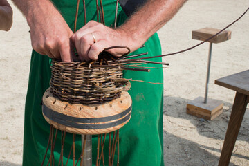 Process of making a basket. Man hands working on it.