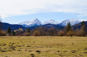 wintery Bavarian alpine village Schwangau with the snowy Alps and Hohenschwangau Castle (Schloss...