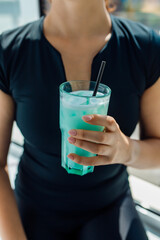 Fototapeta na wymiar Fitness girl holding a glass with sports nutrition drink