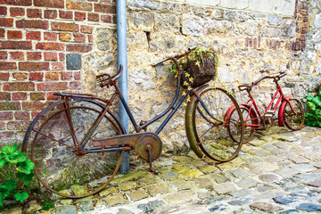 Rusty bycicle on street against brick wall