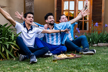 hinchada celebrando el gol  del mundial de futbol, ​​afectando, llorando de la alegria . Con picadas y cervezas, los colores celeste y blanco, luz natural, riendo, gol