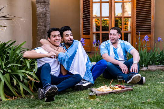 hinchada celebrando el gol  del mundial de futbol, ​​afectando, llorando de la alegria . Con picadas y cervezas, los colores celeste y blanco, luz natural, riendo, gol