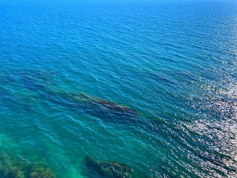 Beautiful blue sea with shiny glittering ripples water aerial view.
