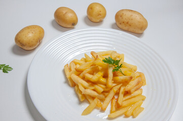 Delicious french fries inside a dish on top of a white background 