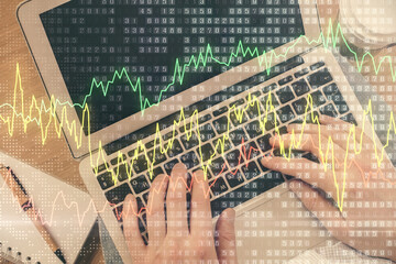 Double exposure of man's hands typing over computer keyboard and forex graph hologram drawing. Top view. Financial markets concept.