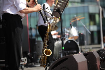 Jazz band of musicians playing on stage by notes background image with a saxophone on a stand