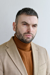 Fototapeta premium Close up portrait of elegant bearded men wearing light beige blazer combined with dark brown sweater. 