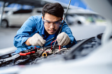 Automotive mechanics repairman use digital voltage multimeter to check voltage level in car battery, check the mileage of the car, auto maintenance service concept.