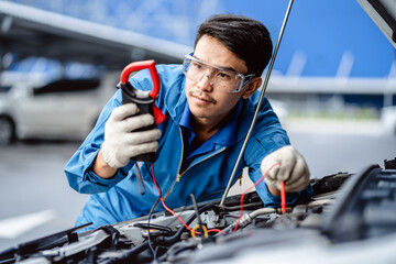 Automotive mechanics repairman use digital voltage multimeter to check voltage level in car...