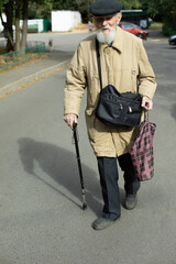 Old man on street. Very old man. Man with walking stick. Longevity in city.