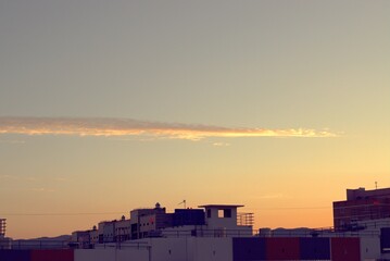 Dawn, sunrise illuminates a funny cloud and the roofs of urban new buildings, a banner, a screensaver.