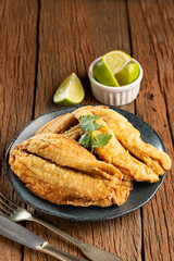 Fried sardines in the plate on the table.