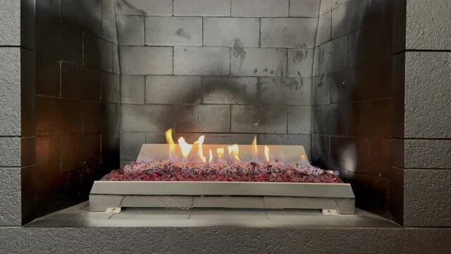 Grey briks fireplace with burning fire
